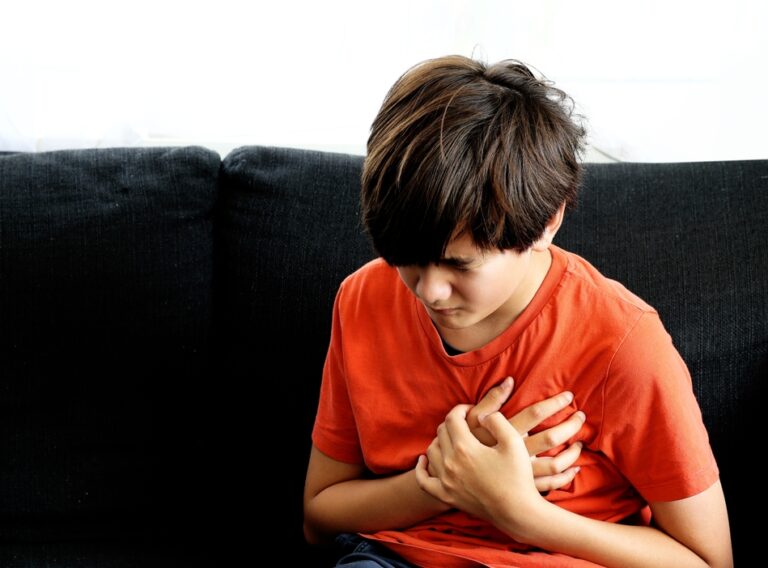Teenager,Boy,Caucasian,Holding,His,Chest,Suffering,From,Pain.,Abnormal