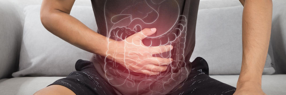 Person holding their stomach in discomfort, illustrating common ulcer symptoms such as burning abdominal pain.