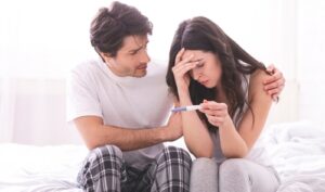 Woman looking concerned while reviewing a fertility checklist about possible signs of infertility in women and menstrual cycle symptoms.