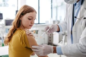 Teen receiving hpv vaccine from healthcare provider, representing cancer prevention and safe vaccination for adolescents