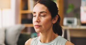 Mind-body exercises to relieve chronic pain naturally in adults: a complete guide 1 Adult practicing mindful breathing and gentle stretching to relieve chronic pain using mind-body exercises