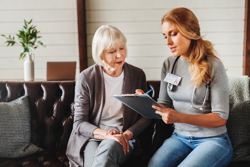 Elderly adult doing gentle stretching at home with caregiver support to relieve chronic pain safely