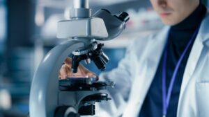 Scientist analyzing stem cells with heart illustration, representing cardiac regeneration therapy and advanced heart repair research
